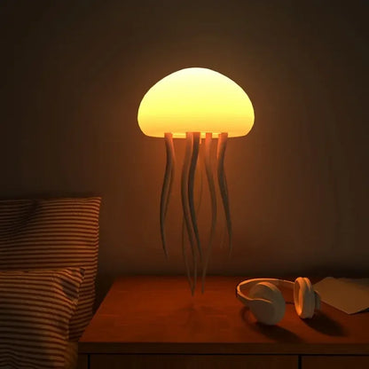Jellyfish-shaped lamp on a bedside table with a pillow and headphones in a dimly lit room.