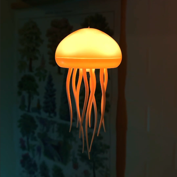 Jellyfish-shaped lamp glowing orange against a dark background