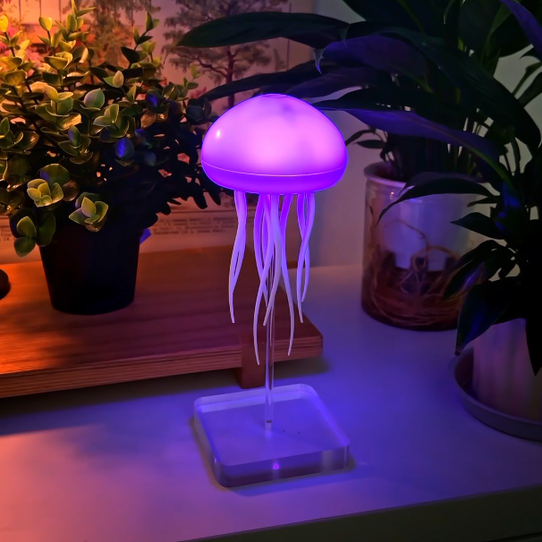 Jellyfish-shaped lamp emitting a purple glow on a surface with plants in the background.